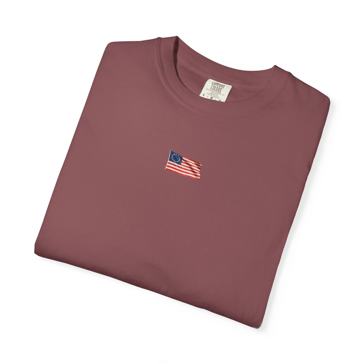 Brick red Course America tee, folded, showing the small American flag chest print