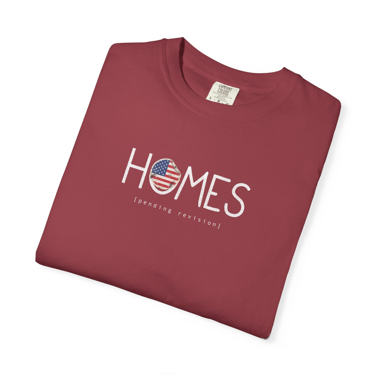 Chili red Course America tee, folded, showing HOMES in white with a flag filled O, above the words pending revision