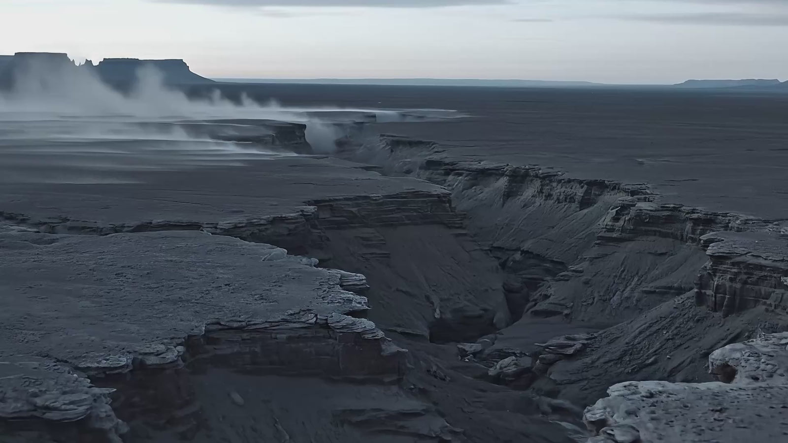 Dark volcanic canyon landscape with steam rising from deep fissures beneath an overcast sky